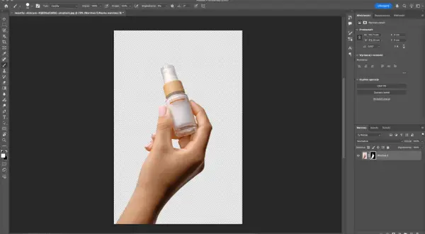 Dłoń trzymająca buteleczkę kosmetyku na przezroczystym tle. Pokazano panel "Szybkie operacje" w Photoshopie, gdzie można wybrać opcję "Usuń tło".
