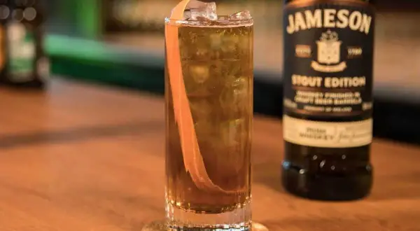 Orzeźwiający drink z whisky Jameson Stout Edition, lodem i skórką pomarańczy. Idealny na wieczór.