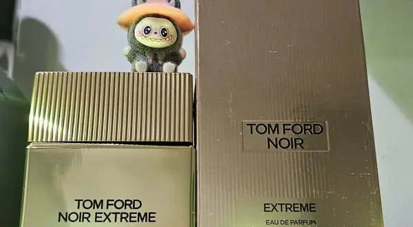 Urocza figurka na flakonie Tom Ford Noir Extreme Parfum. Złote opakowanie i korek dodają elegancji.