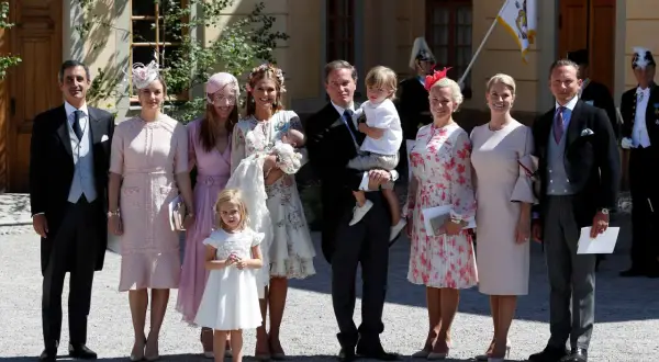 Familie feiert Taufe. Elegante Outfits, die zeigen, was zur Taufe anziehen: zarte Pastelltöne und festliche Kleider.