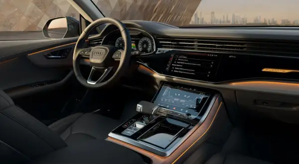 Interni lussuosi dell'Audi Q8 con illuminazione ambientale e schermi digitali.