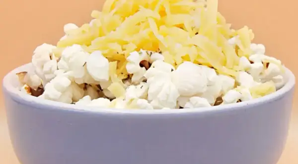 Miseczka popcornu z tartym serem. Pyszna przekąska, ale warto pamiętać o jej popcorn kcal.