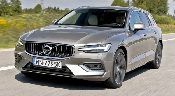 Szary Volvo V60 T5 w ruchu drogowym, z widocznym kierowcą.