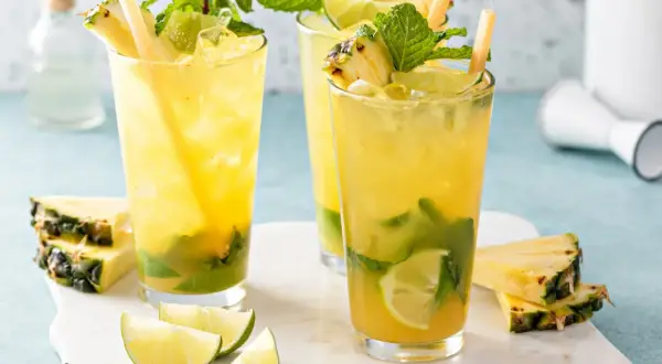 Orzeźwiające augustowskie mojito z ananasem, miętą i limonką, podane z kostkami lodu i słomkami.