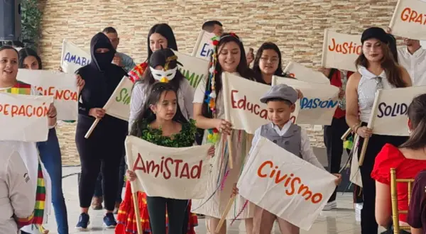 Niños sostienen pancartas con valores como "Amistad", "Civismo" y "Educación", mostrando que es la paz para niños.