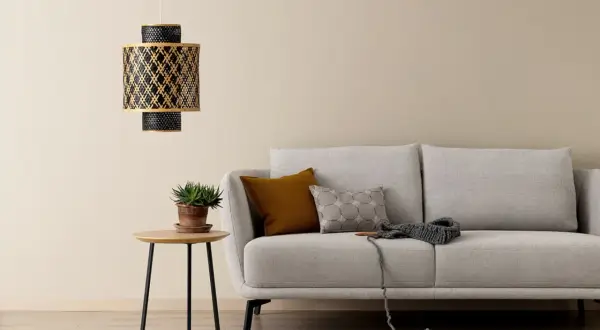 Gemütliches wohnzimmer beige grau weiss mit Sofa, Beistelltisch und Hängeleuchte. Ein Strickprojekt liegt bereit.