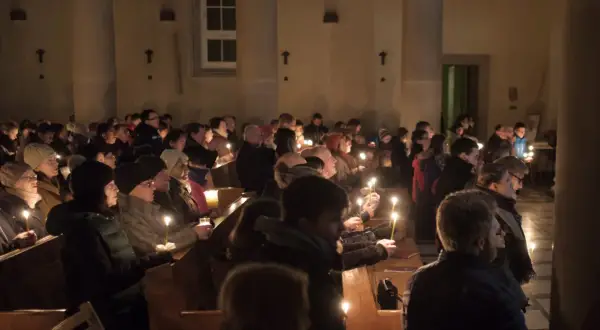 Ludzie z zapalonymi świecami w kościele podczas Rorat. Trwają one przez 24 dni Adwentu.