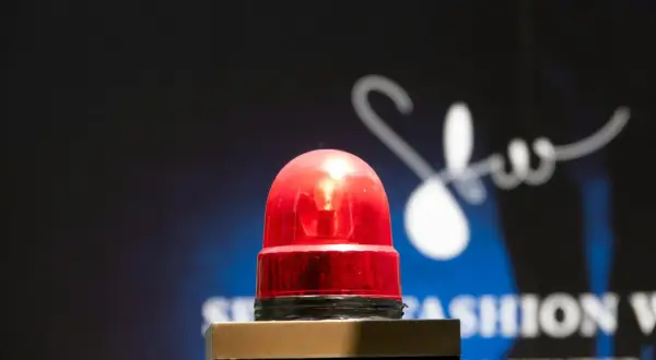 Une sirène rouge clignote, comme son alarme maison, sur un fond sombre avec un logo blanc stylisé.