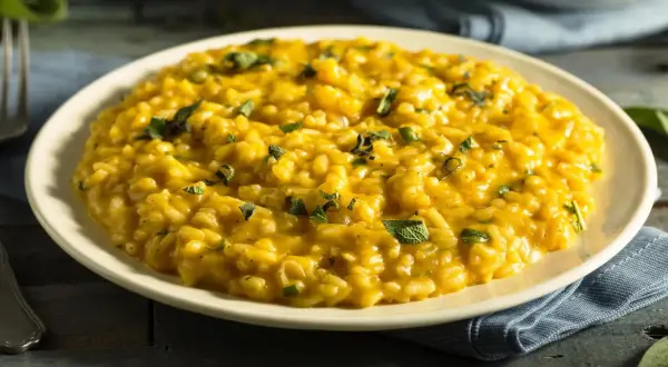 Cremiges, goldgelbes Risotto, garniert mit frischen Kräutern. Ein klassisches Risotto Rezept, das Lust auf mehr macht.