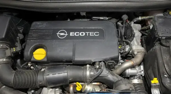 Silnik Ecotec w Opel Meriva 1.7 CDTI. Widoczny czarny plastikowy dekiel z logo Opla i napisem Ecotec, żółty korek oleju, przewody i elementy układu dolotowego.