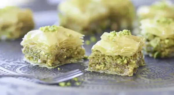 Słodka baklava, co to? Kruche ciasto filo z orzechami i syropem, posypane pistacjami. Idealna na deser.