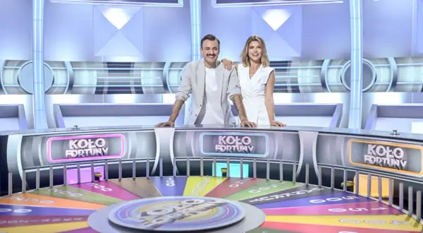 Prowadzący program "Koło Fortuny" stoją przy kole, gotowi do gry.