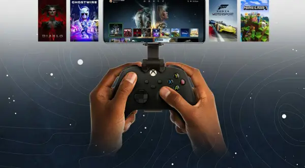 Dłonie trzymające kontroler Xbox, na ekranie smartfona widoczne gry z Xbox Cloud Gaming.
