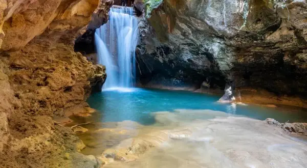 Cascada en una cueva, ideal para excursiones cerca de Zaragoza con agua cristalina y formaciones rocosas.