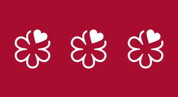 Tres flores blancas con un corazón en cada una, sobre fondo rojo. Símbolo de excelencia culinaria, como en restaurantes con 4 estrellas Michelin.