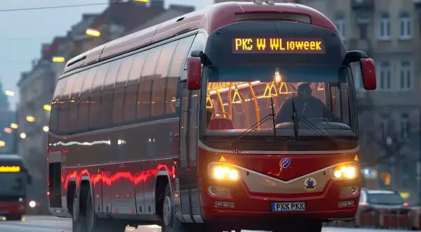 Czerwony autobus PKS jedzie ulicą. Zastanawiasz się, jaka jest pks bilet miesięczny cena?