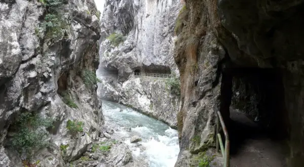 Sendero tallado en roca junto a un río caudaloso, parte de la ruta cain.