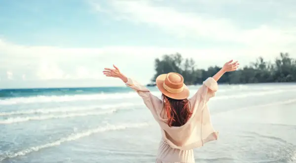 Kobieta w kapeluszu cieszy się plażą, szukając atrakcji dla dzieci pomorskie.