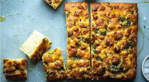En gyllene focaccia långpanna, skuren i bitar, med örter och flingsalt. Perfekt för en mysig fika.