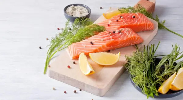 Filetti di salmone fresco, limone, aneto e sale grosso, ingredienti perfetti per una dieta danese sana e gustosa.