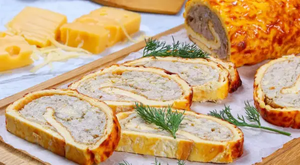 Pyszna rolada serowa z kurczakiem, pokrojona w plastry, z dodatkiem sera i koperku.