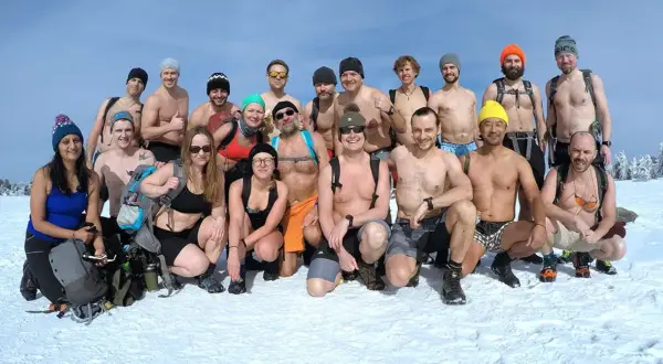 Grupa morsów z Polski, zahartowana metodą Wim Hof, pozuje do zdjęcia na śniegu.