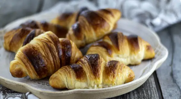 Une assiette de croissants italiens dorés et feuilletés, prêts à être dégustés.