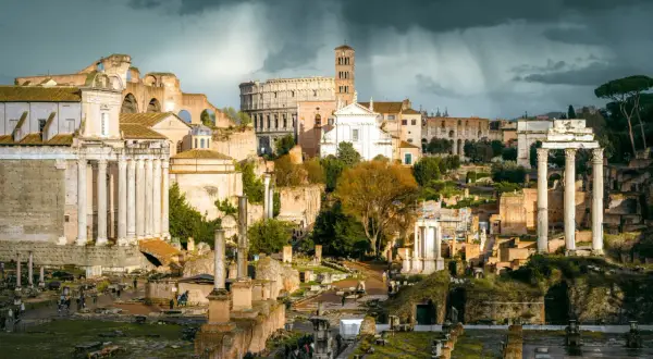 Ruiny Forum Romanum, serce starożytnego Rzymu, pod burzowym niebem. W oddali Koloseum.