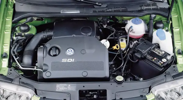 Silnik SDI Volkswagena, z widocznym logo i oznaczeniem, otoczony zielonymi elementami komory silnika.