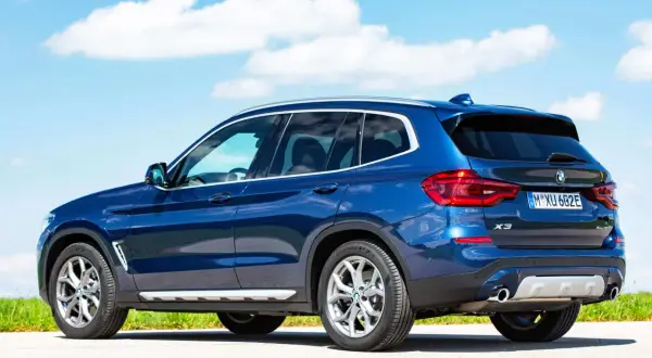 Niebieskie BMW X3 na tle błękitnego nieba. Sprawdź dane techniczne tego SUV-a.