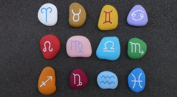 Kolorowe kamienie z symbolami zodiaku, tworzące magiczne znaki ziemskie.