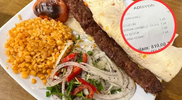 Talerz z daniem kebab, ryżem, sałatką i rachunkiem z ceną 810,00.