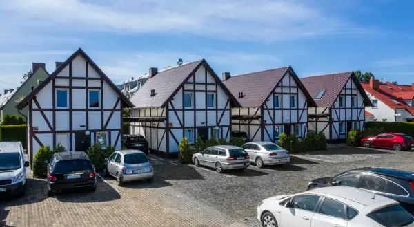 Uroczy ośrodek wypoczynkowy razem nad morzem. Domy w stylu szachulcowym, parking pełen samochodów, gotowych na wakacyjne przygody.