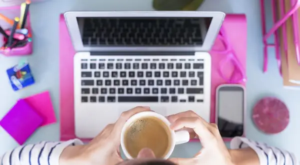 Kawa i laptop na biurku, inspiracja do tego, jaką firmę założyć.