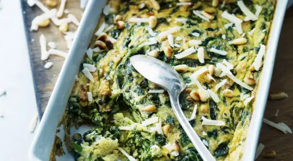 En frittata med spenat och pinjenötter, perfekt för ett snabbt och gott frittata recept. Toppad med riven ost.