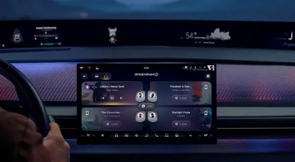 Interno auto con display touch che mostra app musicali. Icona cuffie in alto, suggerisce come collegare bluetooth per ascoltare musica.