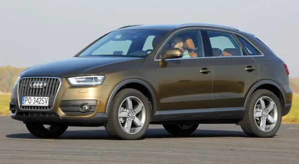 Brązowy Audi Q3 8U z brązową tapicerką, kierowca w tle.