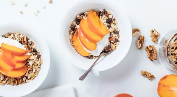 Bol de granola avec yaourt, fruits et noix. Le flocon d'avoine, valeur nutritionnelle, est un excellent choix pour un petit-déjeuner sain.