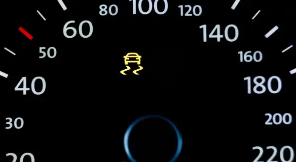 Kontrolka DSC świeci się na desce rozdzielczej, ostrzegając o śliskiej nawierzchni. Prędkościomierz pokazuje 40 km/h.