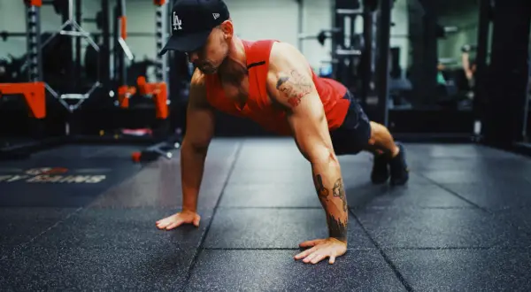 Mann in einem Fitnessstudio macht Liegestütze, um seinen Bewegungsradius zu verbessern.