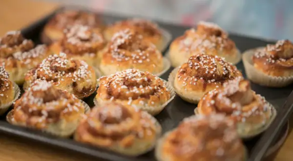 Nybakade kanelbullar, perfekta att baka glutenfritt. Dessa gyllene godsaker med pärlsocker ser ljuvliga ut.