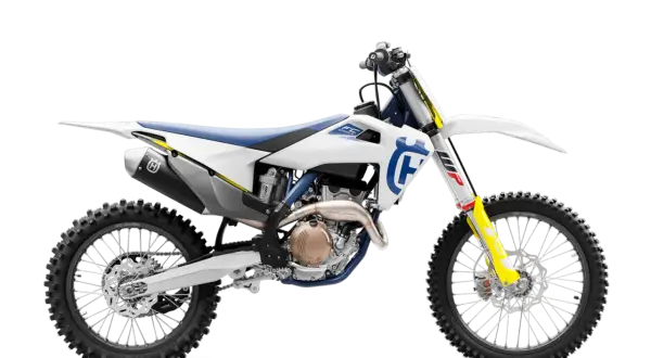 Biały motocykl Husqvarna FC 250 z niebieskim siedzeniem i żółtymi akcentami, gotowy do jazdy po torze.
