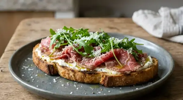 Tartine gourmande avec un accompagnement carpaccio de boeuf, roquette fraîche et copeaux de parmesan. Un délice pour les papilles.