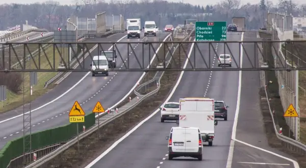 Ruch na drodze S11 Kórnik-Jarocin. Samochody i furgonetki jadą w kierunku Kołobrzegu. Znaki ostrzegają przed dzikimi zwierzętami i śliską nawierzchnią.