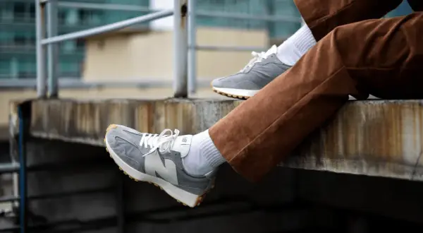 Szare New Balance na nogach w brązowych sztruksach. Zastanawiasz się, czy new balance można prać w pralce? Te wyglądają na czyste!