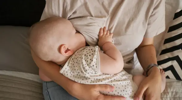 En bebis ammar. En mamma håller sitt barn nära. Dagen efter piller amning kan kännas annorlunda, men lugnet i stunden är detsamma.