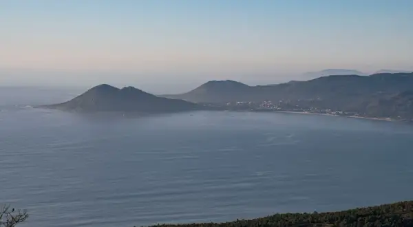 Vista panorámica de la costa gallega con el monte Enxa destacando sobre el mar azul.
