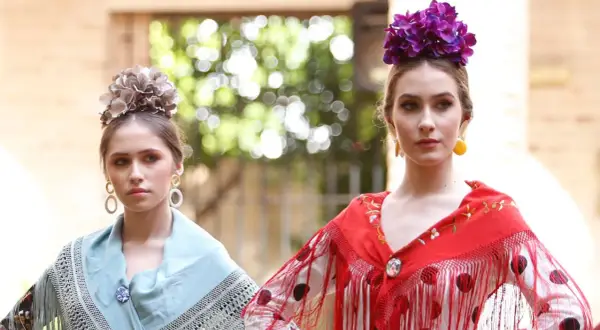 Dos jóvenes con maquillaje flamenca, flores en el pelo y mantones de seda.
