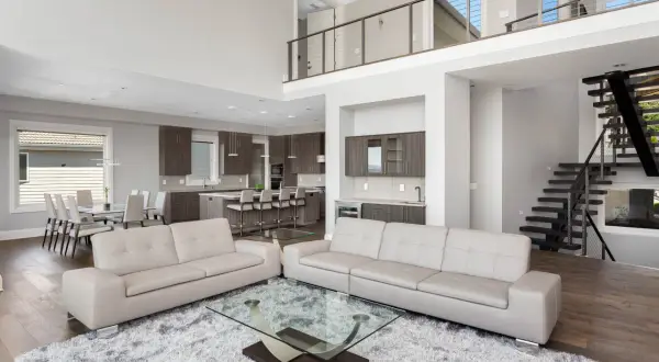 Spacious modern living room with a kitchen and dining area, captured with a real estate photography lens to showcase its open-concept design.
