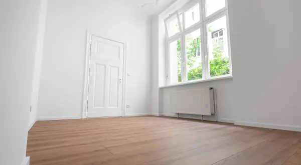 Puste, jasne mieszkanie z białymi ścianami, drzwiami i oknem. Drewniana podłoga. Zastanawiasz się, ile się czeka na mieszkanie komunalne?